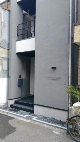 a white building with a door on the side of it at CASA Higashi Mikuni 02 in Osaka