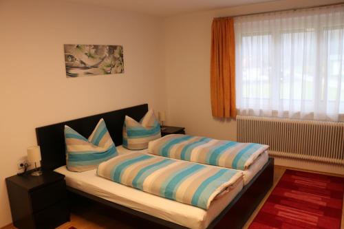 a bedroom with a bed with two pillows on it at Gästehaus Schoder in Vandans