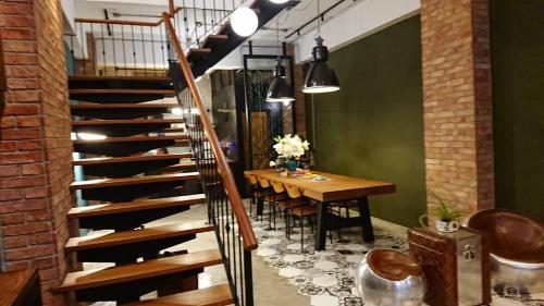 a dining room with a table and a staircase at Mr. Buster B&B in Hualien City