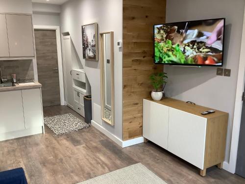 a kitchen with a flat screen tv on a wall at Carolyn’s Place in Ruislip