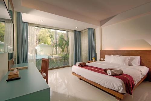 a bedroom with a large bed and a large window at Baan Karon Resort in Karon Beach