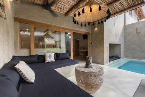 a living room with a couch and a swimming pool at Karma Resort in Bophut 