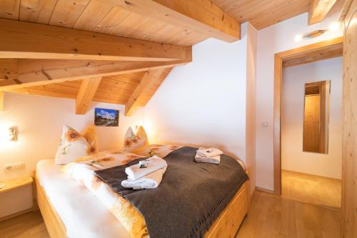 a bedroom with a bed in a room with wooden ceilings at Ferienhaus Gundi in Pettneu am Arlberg