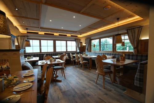 a restaurant with wooden tables and chairs and windows at Gasthaus Goglhof in Fügenberg