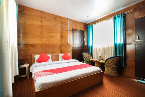 a bedroom with a large bed with red pillows at Silver Dew Resorts in Dhanaulti