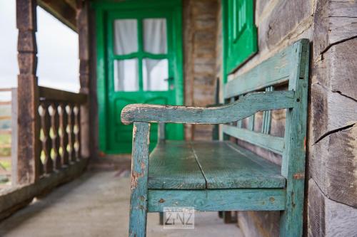 a wooden bench sitting in front of a green door at Casa Glod in Glod