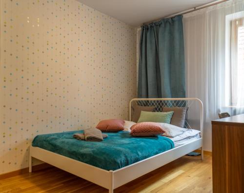 a bedroom with a bed with a blue comforter at Nozownicza Street Apartment in Wrocław