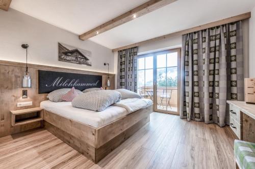 ein Schlafzimmer mit einem großen Bett und einem großen Fenster in der Unterkunft Gasthaus Goglhof in Fügenberg