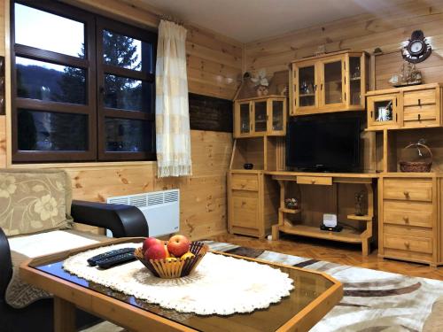 a living room with a table with a bowl of fruit on it at Stone Lodge 2 in Kolašin