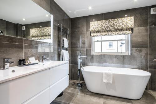 a bathroom with a large tub and a sink at The H Boutique Hotel in Bakewell