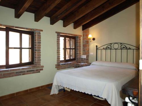 a bedroom with a bed and two windows at La Currada in Taranes