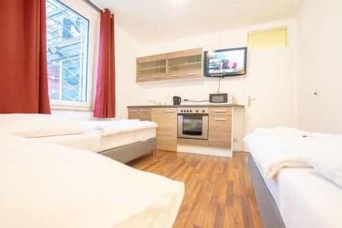 um quarto de hospital com camas brancas e uma televisão em Lovely City House em Meerbusch