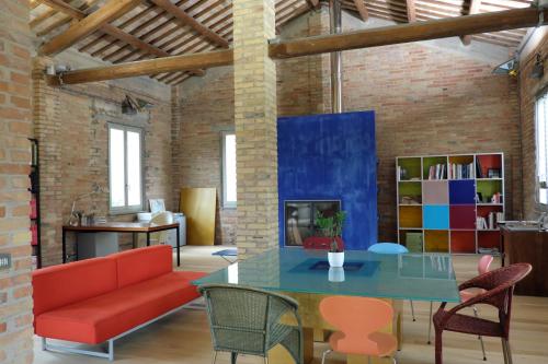 a living room with a red couch and a table at INVENTO bnb unconventional maison in Civitanova Marche