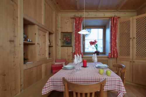 comedor con mesa y cortina roja en Villa Christina, en San Candido