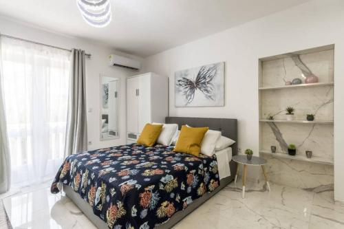 a bedroom with a bed with yellow pillows at Royal Platinum Studio Apartment in Vodice