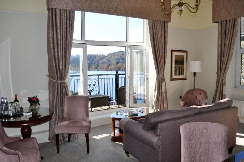 a living room with a couch and a table and a window at Macdonald Old England Hotel & Spa in Bowness-on-Windermere