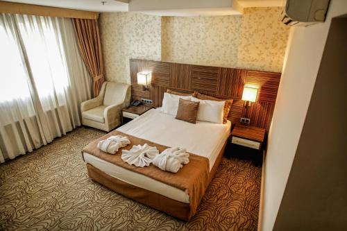 a hotel room with a bed and a chair at Grand Denizli Hotel in Denizli
