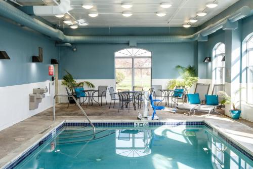 a pool with chairs and tables in a room with blue walls at Country Inn & Suites by Radisson, Harrisburg West Mechanicsburg in Mechanicsburg