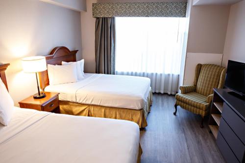 a hotel room with two beds and a television at Country Inn & Suites by Radisson, Harrisburg West Mechanicsburg in Mechanicsburg