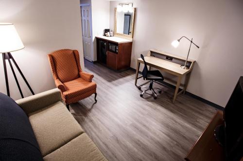 a living room with a desk and a chair at Country Inn & Suites by Radisson, Harrisburg West Mechanicsburg in Mechanicsburg
