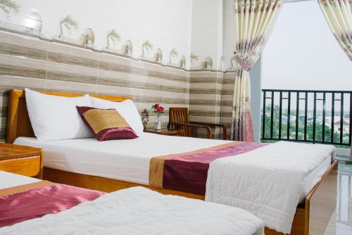 a hotel room with two beds and a balcony at HIEP HOA HOTEL in Chau Doc