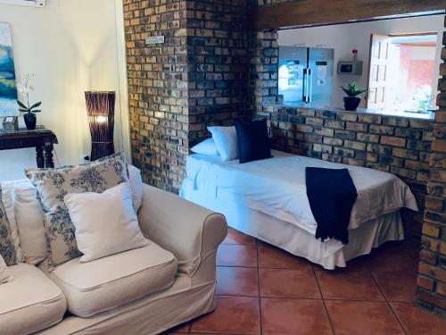 a living room with a bed and a couch at Modjadji Estate Lodge & Spa in Grietjie Nature Reserve