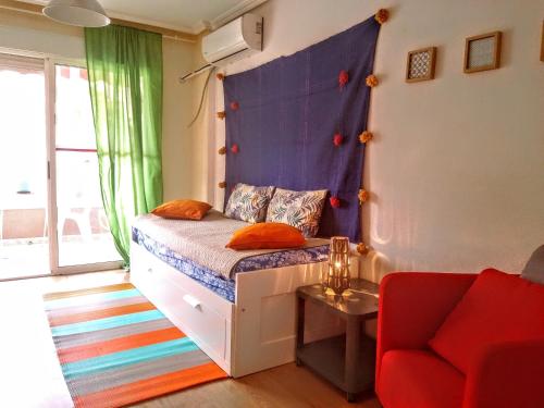 a bedroom with a bed with a headboard and a couch at Playa Lisa Studio in Santa Pola