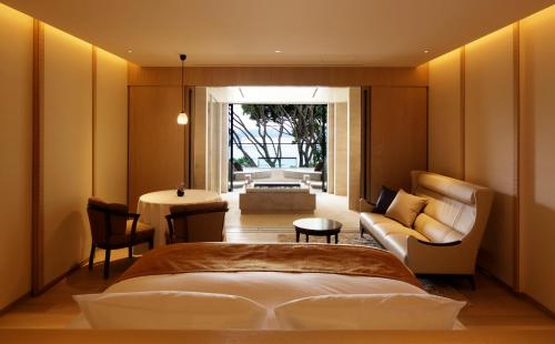 a bedroom with a bed and a couch and a table at THE HIRAMATSU HOTELS & RESORTS KASHIKOJIMA in Shima