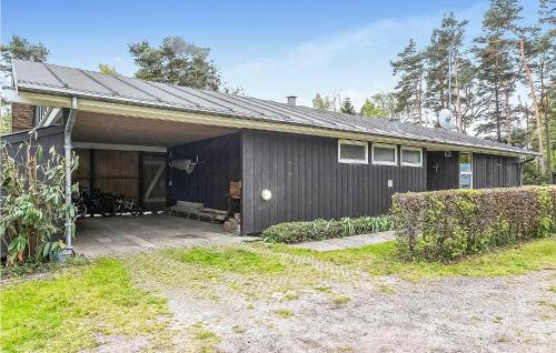 a black house with a garage and a driveway at Awesome Home In Gedser With Sauna in Gedser