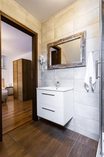 a bathroom with a white sink and a mirror at Gold Rooms in Koszalin