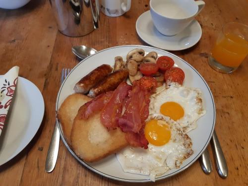 Un plato de desayuno con huevos, tocino y salchichas. en Woodlands Cottage Farm, en Wickham