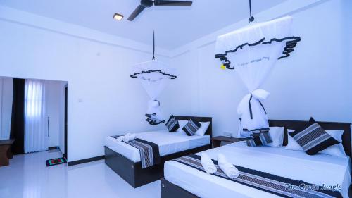 1 dormitorio con 2 camas y pared azul en The Green Jungle, en Dambulla