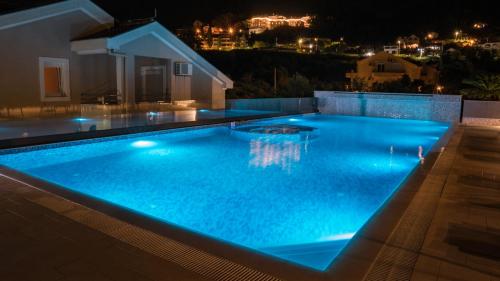a swimming pool at night with a house at Sun Village Aparthotel in Herceg-Novi