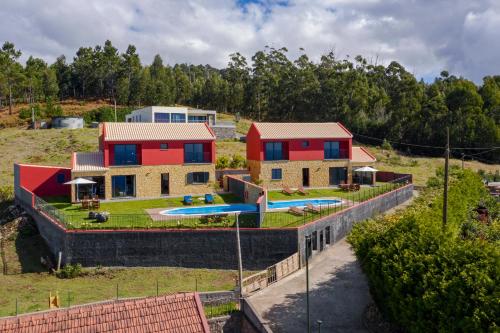 a house on a hill with a swimming pool at Vilas Felicidade Rocha by An Island Apart in Ponta do Pargo