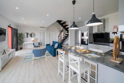 a kitchen and living room with a blue couch at Vilas Felicidade Rocha by An Island Apart in Ponta do Pargo