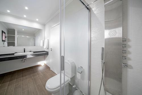 a white bathroom with a toilet and a shower at Vilas Felicidade Rocha by An Island Apart in Ponta do Pargo