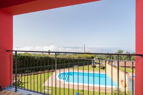 a balcony with a view of a swimming pool at Vilas Felicidade Rocha by An Island Apart in Ponta do Pargo