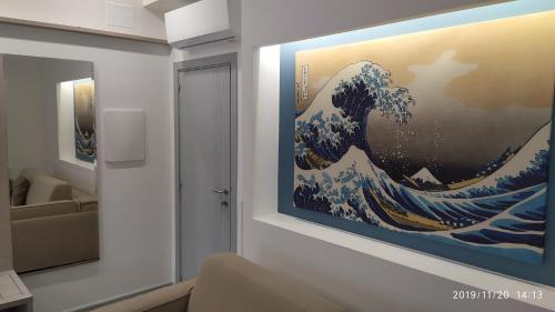 a painting of a wave on a wall in a room at B&B La Stazione in Diamante