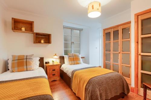 コムリーにあるDundas Flat, 1 bedroom, Comrieのベッド2台と窓のある寝室