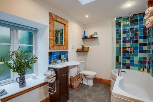 a bathroom with a sink and a toilet and a tub at Dundas Flat, 1 bedroom, Comrie in Comrie