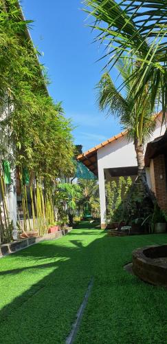a green yard with palm trees and a building at Phú Vy Bungalow Phú Quốc in Phú Quốc