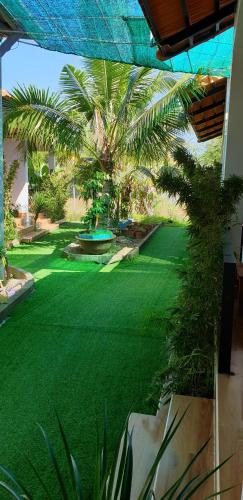 a yard with a green lawn with palm trees at Phú Vy Bungalow Phú Quốc in Phú Quốc