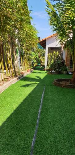 a yard with green grass and palm trees and a house at Phú Vy Bungalow Phú Quốc in Phú Quốc