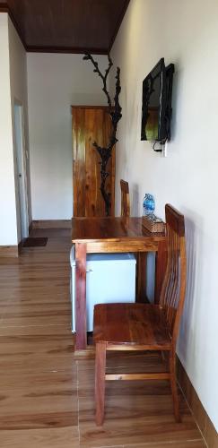 a wooden table with a chair and a television at Phú Vy Bungalow Phú Quốc in Phú Quốc