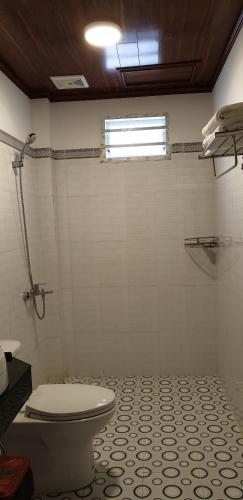 a bathroom with a toilet and a tiled floor at Phú Vy Bungalow Phú Quốc in Phú Quốc