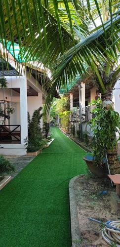 a room with green artificial grass in a building at Phú Vy Bungalow Phú Quốc in Phú Quốc