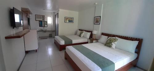 a hotel room with two beds and a bathroom at MR Holidays Hotel in Boracay