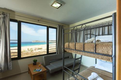 a bedroom with a bunk bed and a view of the beach at Pachia Ammos Falasarna in Falasarna