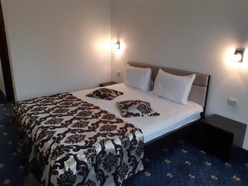 a bed in a small room with two pillows on it at Hotel Ro&Mario Barlad in Bîrlad