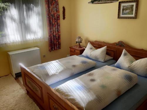 two twin beds in a bedroom with a window at Loibl Max in Bad Griesbach